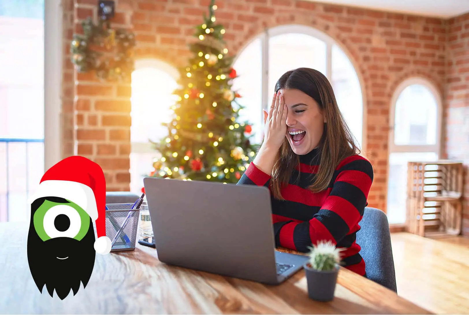 A smiling woman in a red and black striped sweater sits at a table with a laptop, covering one eye in surprise. A Christmas tree is in the background. A cartoon character with a Santa hat is in the foreground.