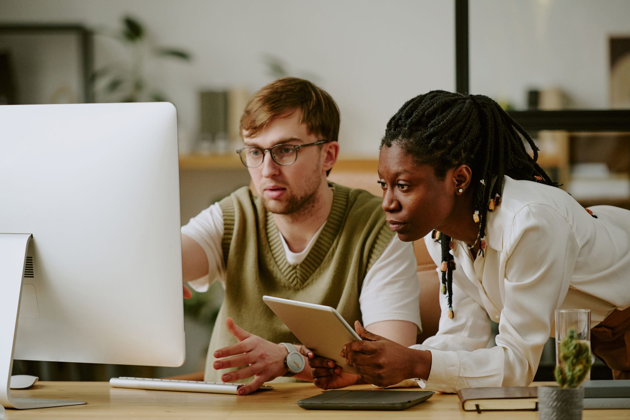 Man and Woman Staring at Monitor of Computer in Office