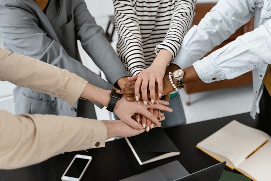 équipe qui joint ses mains pour collaborer