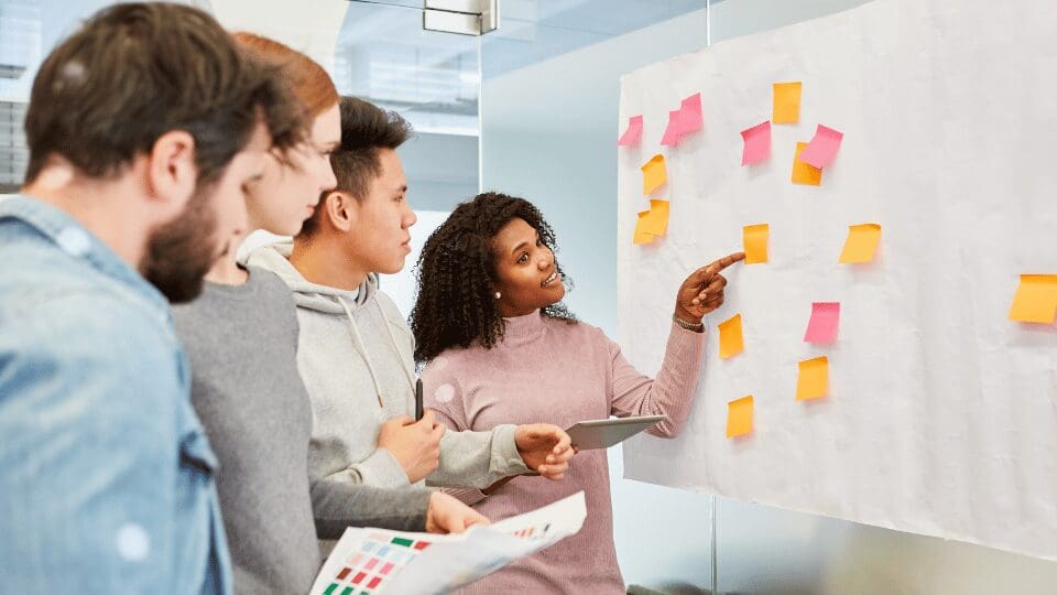 équipe en brainstorming sur un tableau blanc